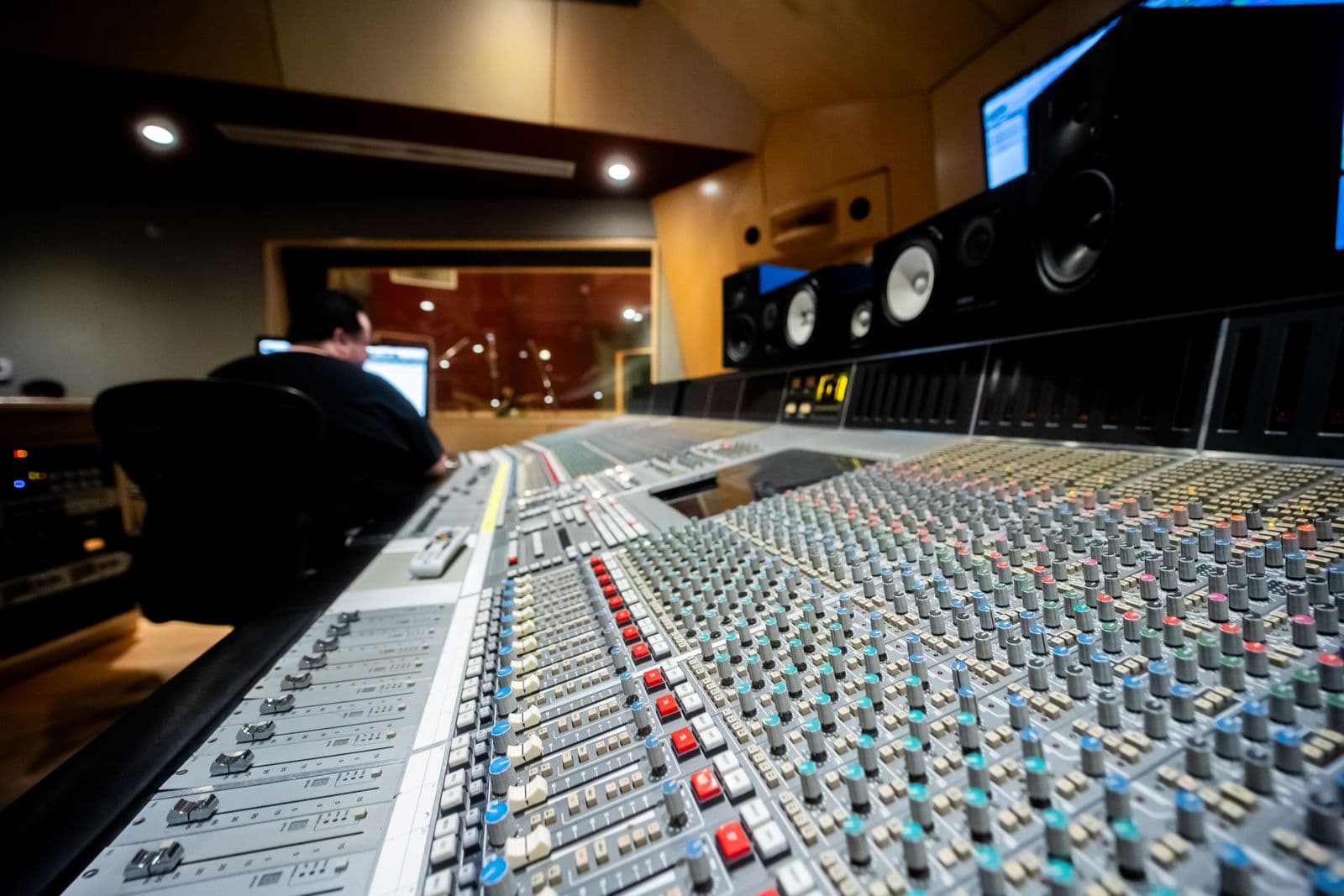 An engineer working at a large recording studio mixing console