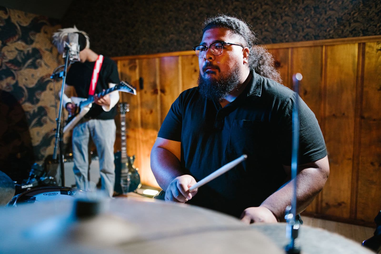 A drummer and guitarist rehearsing together